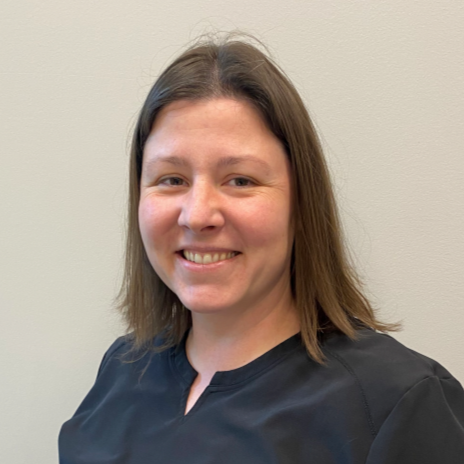 Chiropractic Lacey WA Stephanie Meet The Team Stephanie smiling for photo in front of white wall.